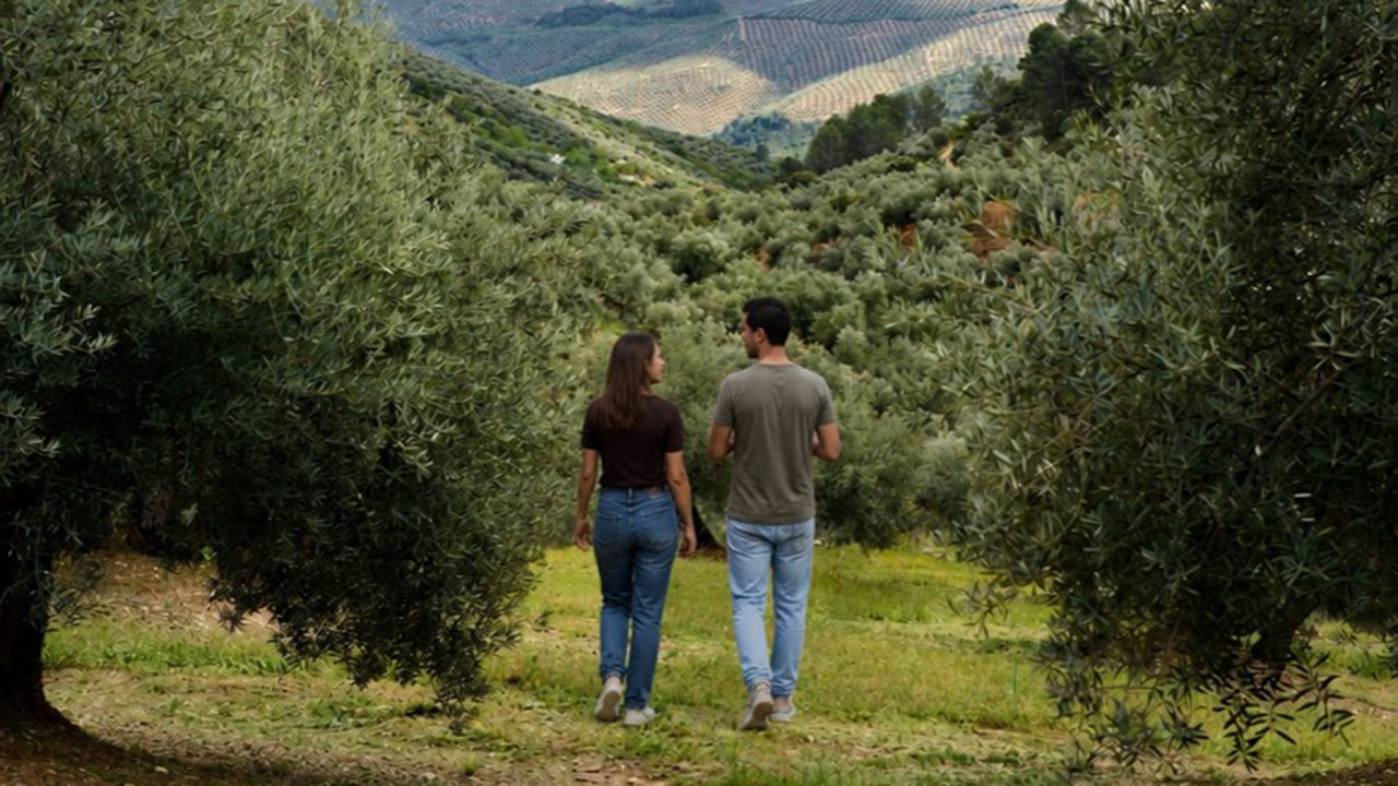 Dos personas caminando por un sendero de montaña rodeado de vegetación mediterránea en la provincia de Jaén